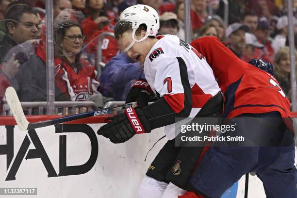 Brady Tkachuk of the Ottawa Senators is checked by Matt Niskanen of the Washington Capitals during the first period at Capital One Arena on February...