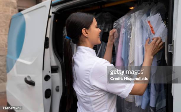 friendly woman werken voor een wasserettedienst het nemen van kleding aan klanten in delivery van - dry cleaning stockfoto's en -beelden