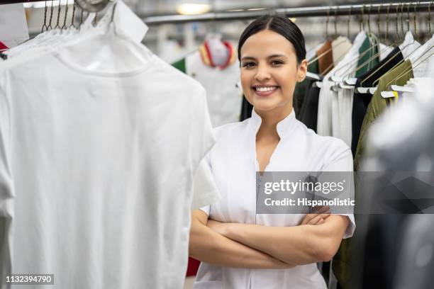 confiant gestionnaire assez jeune travaillant à une laverie automatique face souriant - dry cleaning photos et images de collection