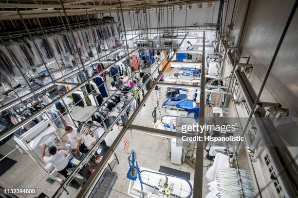 people working at an industrial laundry service - lavandaria imagens e fotografias de stock