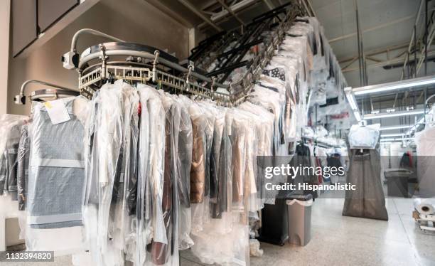 industrial laundry service with conveyor belt - dry cleaning shop stock pictures, royalty-free photos & images