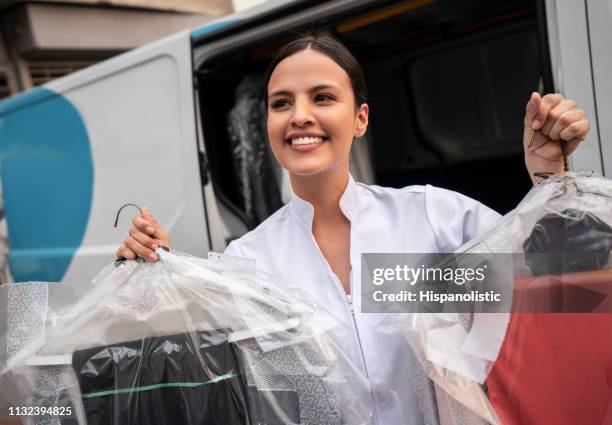 hermosa mujer reflexiva mirando lejos mientras entrega ropa limpia en seco - laundromat fotografías e imágenes de stock