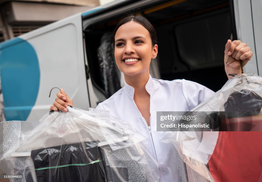 Beautiful thoughtful woman looking away while delivering dry cleaned clothes