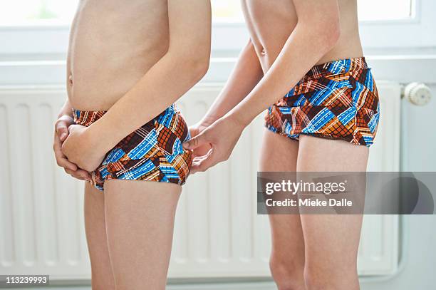 boy squeezing his brothers bottom - ass six stock pictures, royalty-free photos & images
