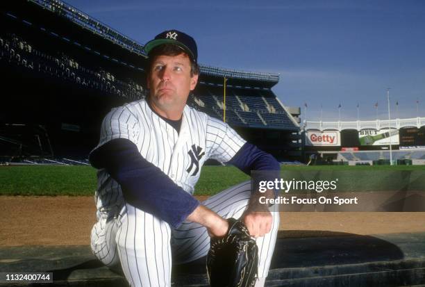 Tommy John of the New York Yankees looks on from the dugout prior to the start of a Major League Baseball game circa 1987 at Yankee Stadium in the...