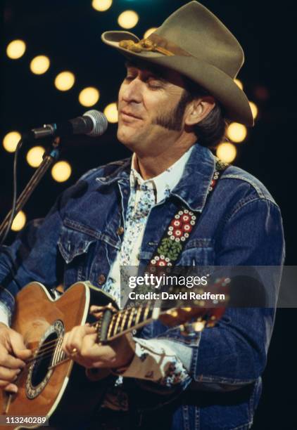 Don Williams, U.S. Country music singer-songwriter, singing into a microphone and playing the guitar during a live concert performance at the...