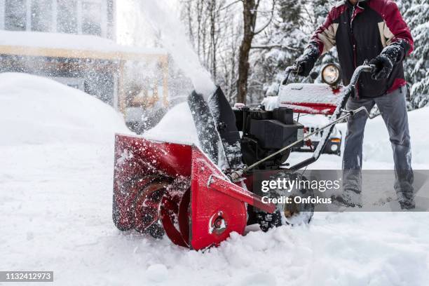 senior man met behulp van sneeuwblazer na een sneeuwstorm - sneeuwschuiver stockfoto's en -beelden