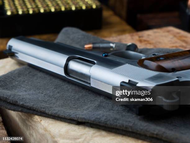 close up pistol gun barrel and wooden and dark black ground - ammunition magazine stockfoto's en -beelden