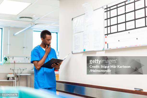confident male nurse with file in hospital - nurse thinking stock pictures, royalty-free photos & images