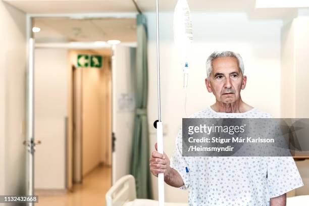 thoughtful senior patient holding iv drip - hospital bed with iv stock pictures, royalty-free photos & images