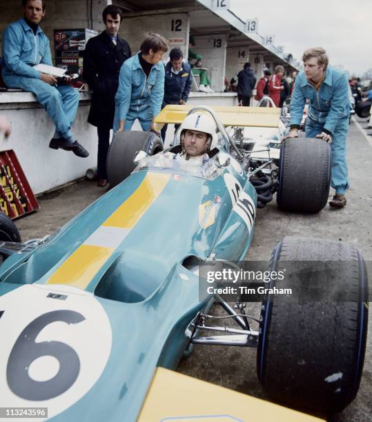 Jack Brabham aboard the Motor Racing Developments Brabham BT33 Ford Cosworth DFV 3.0 V8 waits in the pits as his mechanics overseen by Ron Dennis...