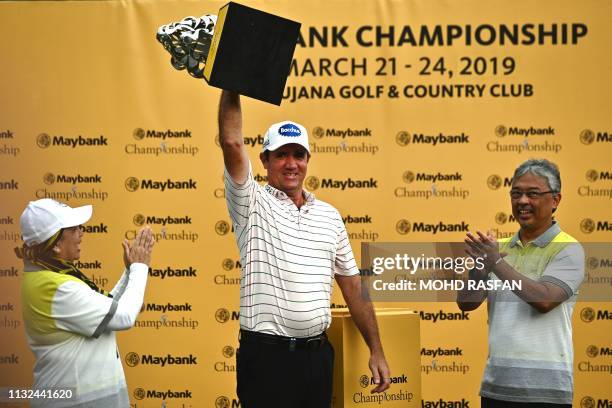 Scott Hend of Australia lifts up his trophy as Malaysia's King Sultan Abdullah Sultan Ahmad Shah applauds after winning the 2019 Maybank Malaysia...