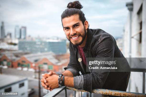 retrato de um homem latin que sorri e que olha na câmera - coque cabelo para cima - fotografias e filmes do acervo