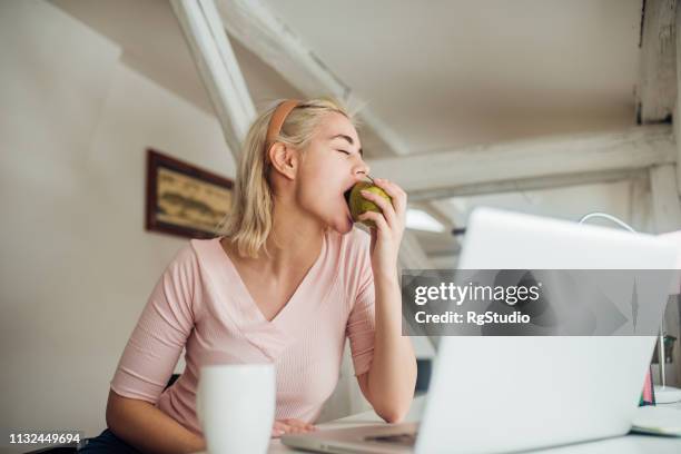 mädchen essen einen apfel - office snack stock-fotos und bilder