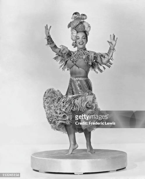 Portrait of singer and actress Carmen Miranda wearing an elaborate headdress and costume in the 1940's.