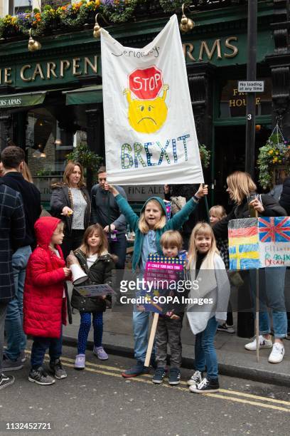 Kid seen holding onto a hanging anti Brexit banner during the protest. Over one million protesters gathered at the People's Rally in London demanding...