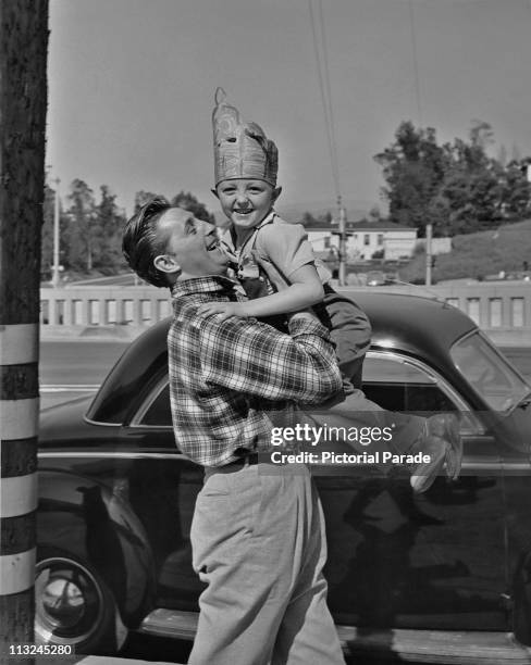 American actor Robert Mitchum playing with his son James circa 1946.