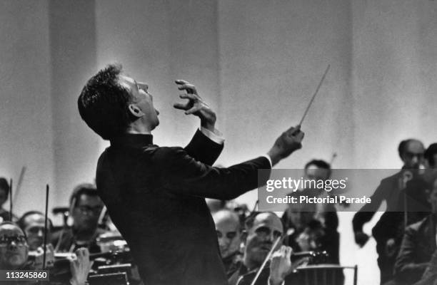 American composer and conductor Leonard Bernstein performing, with his mouth open and using exaggerated gestures, circa 1950's.