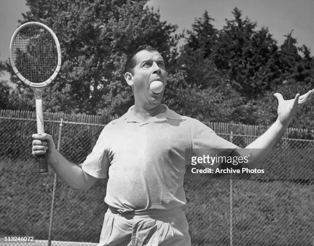 American comedian and actor Milton Berle with a tennis ball in his mouth while on holiday from his Texaco Star Theatre television show circa 1951.