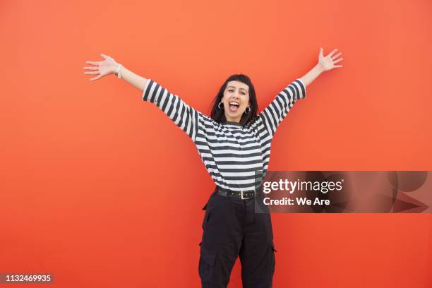 young woman with arms outstretched in carefree moment. - monocromo vestimenta fotografías e imágenes de stock