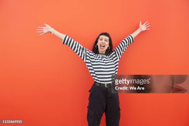 young woman with arms outstretched in carefree moment. - armen omhoog stockfoto's en -beelden