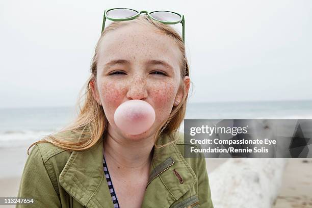 girl blowing bubble on the beach - bubble gum kid stock pictures, royalty-free photos & images