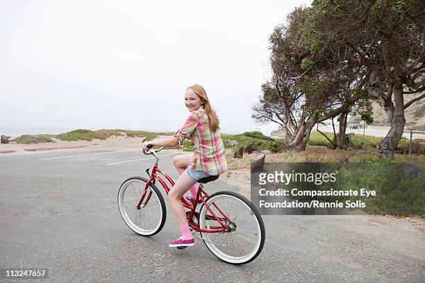 teenage girl riding a red bike along the beach - 13 year old girls in shorts stock pictures, royalty-free photos & images