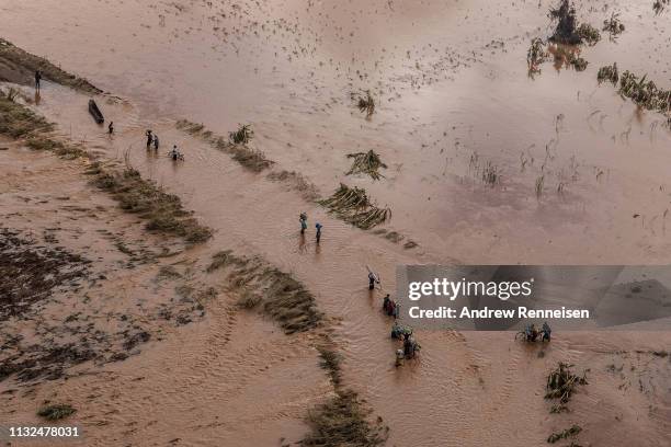 People wade through flood waters in a rural neighborhood affected by Cyclone Idai on March 24, 2019 in Buzi, Mozambique. Emergency personnel are...