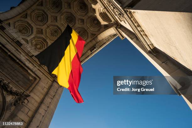 belgian flag in arcade du cinquantenaire - belgië stockfoto's en -beelden