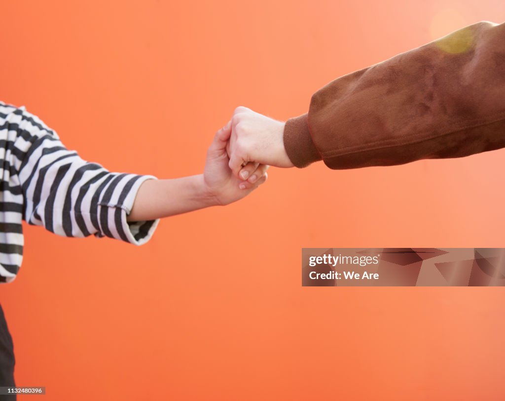 Two friends holding hands.