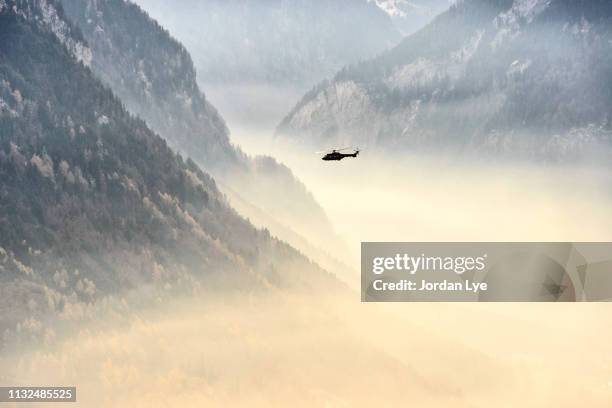 helicopter flying on a mountain range - befreiung stock-fotos und bilder