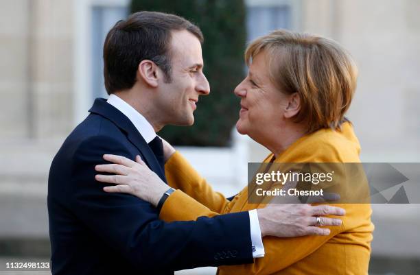 French President Emmanuel Macron welcomes German Chancellor Angela Merkel prior to their meeting at the Elysee Presidential Palace on February 27,...