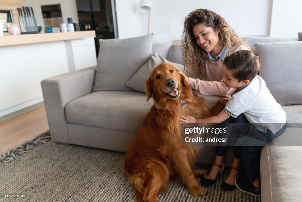 Feliz madre e hijo en casa acariciando su perro