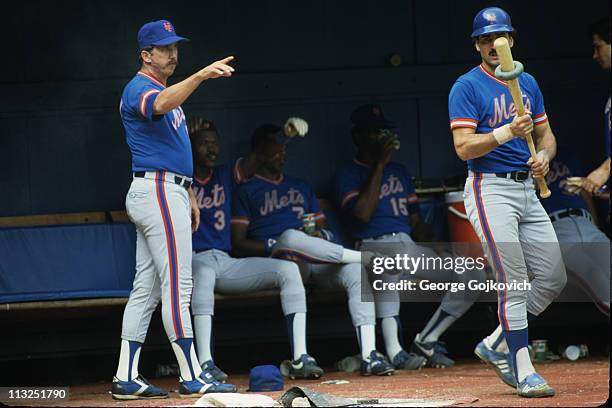 Manager Davey Johnson of the New York Mets points as Keith Hernandez prepares to bat as Rafael Santana, Hubie Brooks and George Foster look on from...