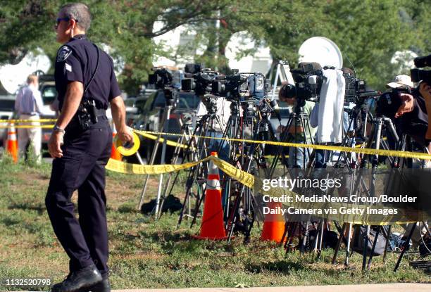 Boulder County Sheriff's Deputy K. Parker puts up police tape around the media before the JonBenet Ramsey press conference on Thursday.