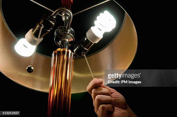 hand pulling light switch - light bulb fotografías e imágenes de stock