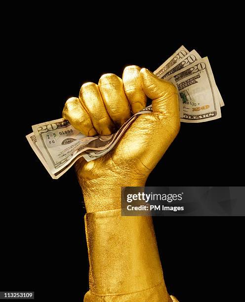 golden hand clutching money - greed fotografías e imágenes de stock