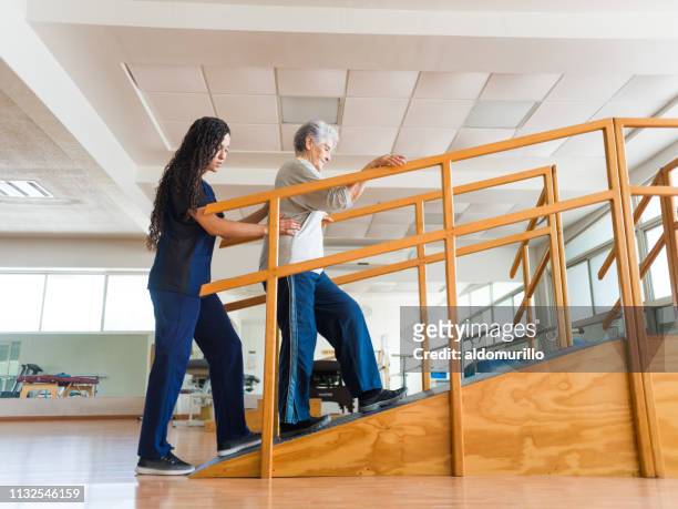 senior woman going up a ramp during physical therapist - rehabiltation stock pictures, royalty-free photos & images