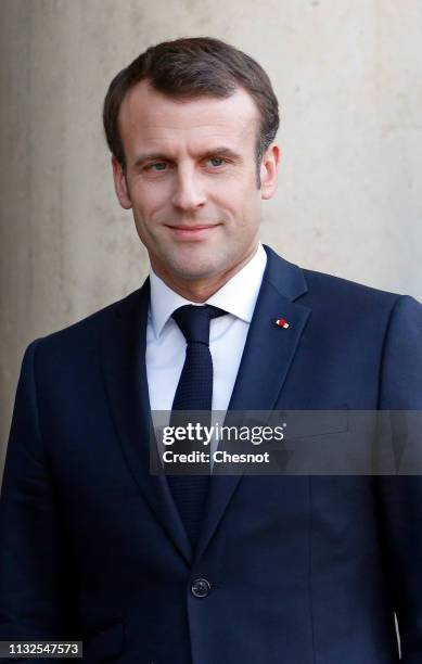 French President Emmanuel Macron waves as German Chancellor Angela Merkel leaves the Elysee Presidential Palace after their meeting on February 27,...