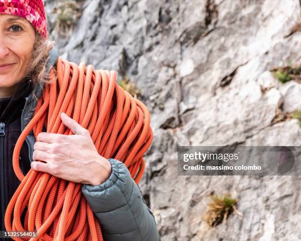 alpinist woman with climbing rope looking up - kletterseil stock-fotos und bilder