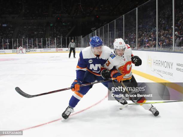 Ryan Pulock of the New York Islanders checks Johnny Gaudreau of the Calgary Flames at NYCB Live's Nassau Coliseum on February 26, 2019 in Uniondale,...