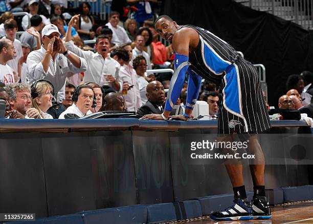 Dwight Howard of the Orlando Magic stands at the scorer's table after being earning a technical foul against Zaza Pachulia of the Atlanta Hawks...