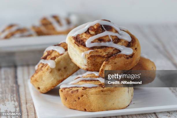 cinnamon rolls with icing - cinnamon bun stock pictures, royalty-free photos & images