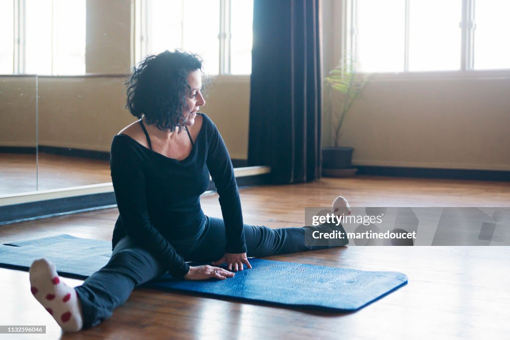 Mature woman instructor of stretching class.