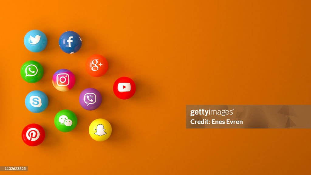 Sphere shape of marble Social media services icons on an orange desk