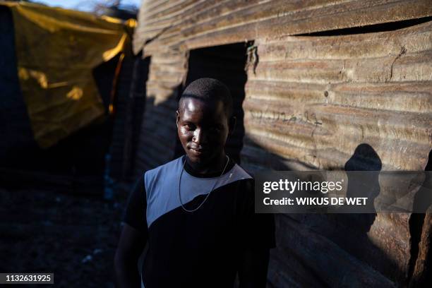 Zacaria Machangu, whose house was partly damaged, poses for a portrait outside his damaged house in the Praia Move area in Beira, Mozambique on March...