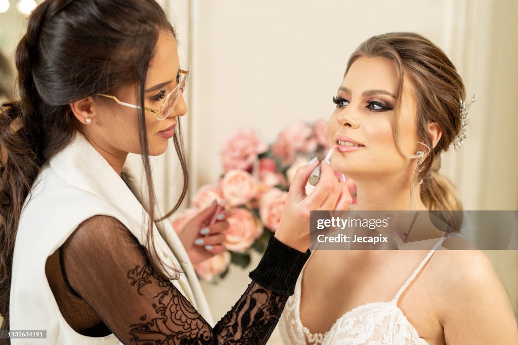 Make up artist preparing bride for wedding