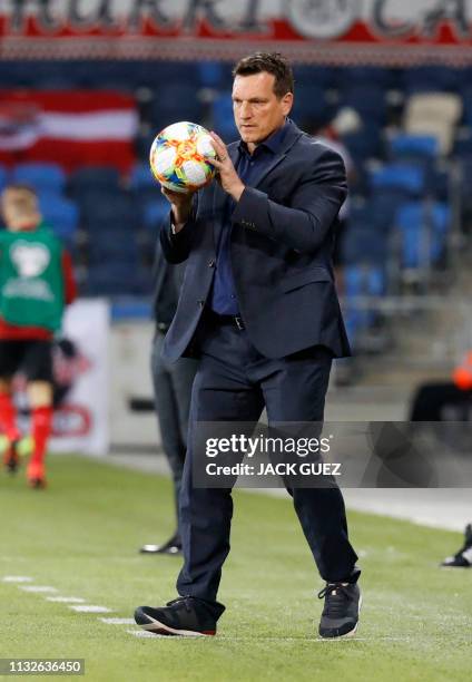 Israel's head coach Andi Herzog returns the ball to the field during the Euro 2020 Group G football qualification match between Israel and Austria at...