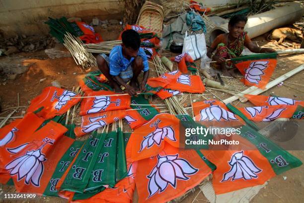 Slum dewllers are hired by Bharatiya Janata Party to prepare their party logo flags ahead of the general election campaigning in India at the eastern...