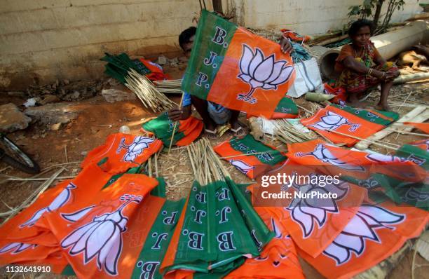 Slum dewllers are hired by Bharatiya Janata Party to prepare their party logo flags ahead of the general election campaigning in India at the eastern...